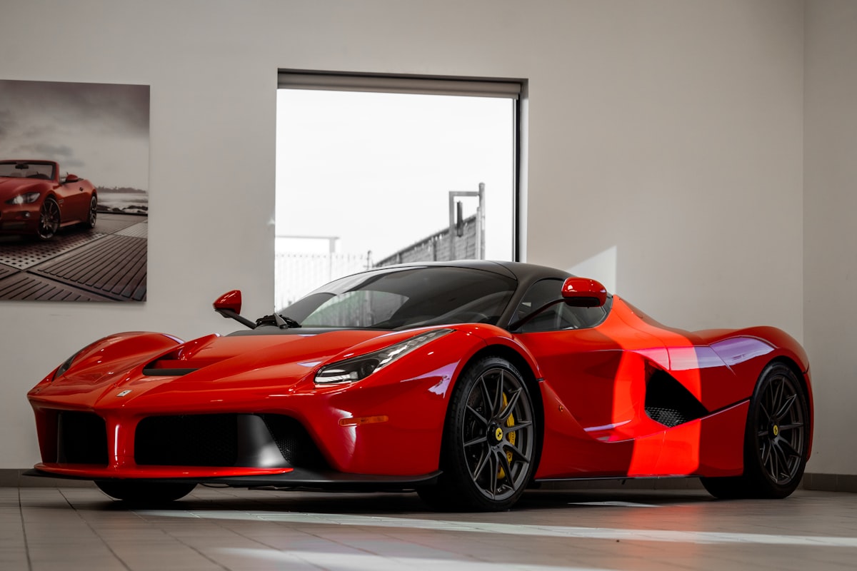 Red Ferrari 458 Italia supercar parked in front of a white wall