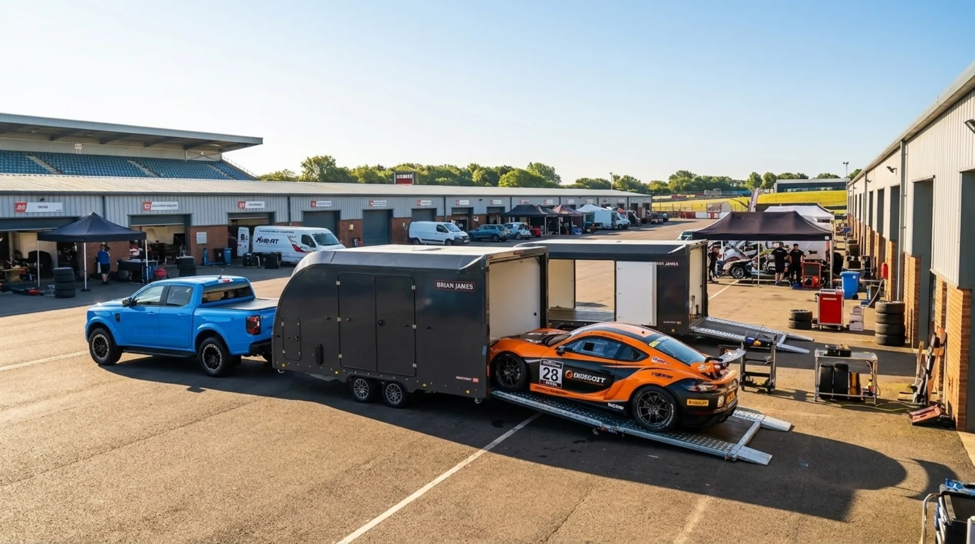 Race-liveried sports car unloading in a sunny circuit paddock